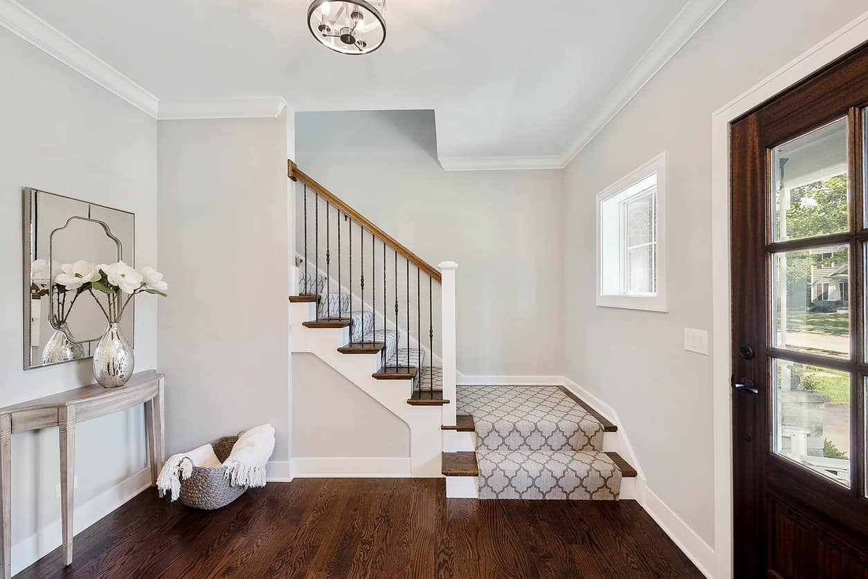 Interior House Painting – Foyer & Entryway Home foyer with gray walls, white crown molding, and dark hardwood floors — interior house painting Middlesex County MA