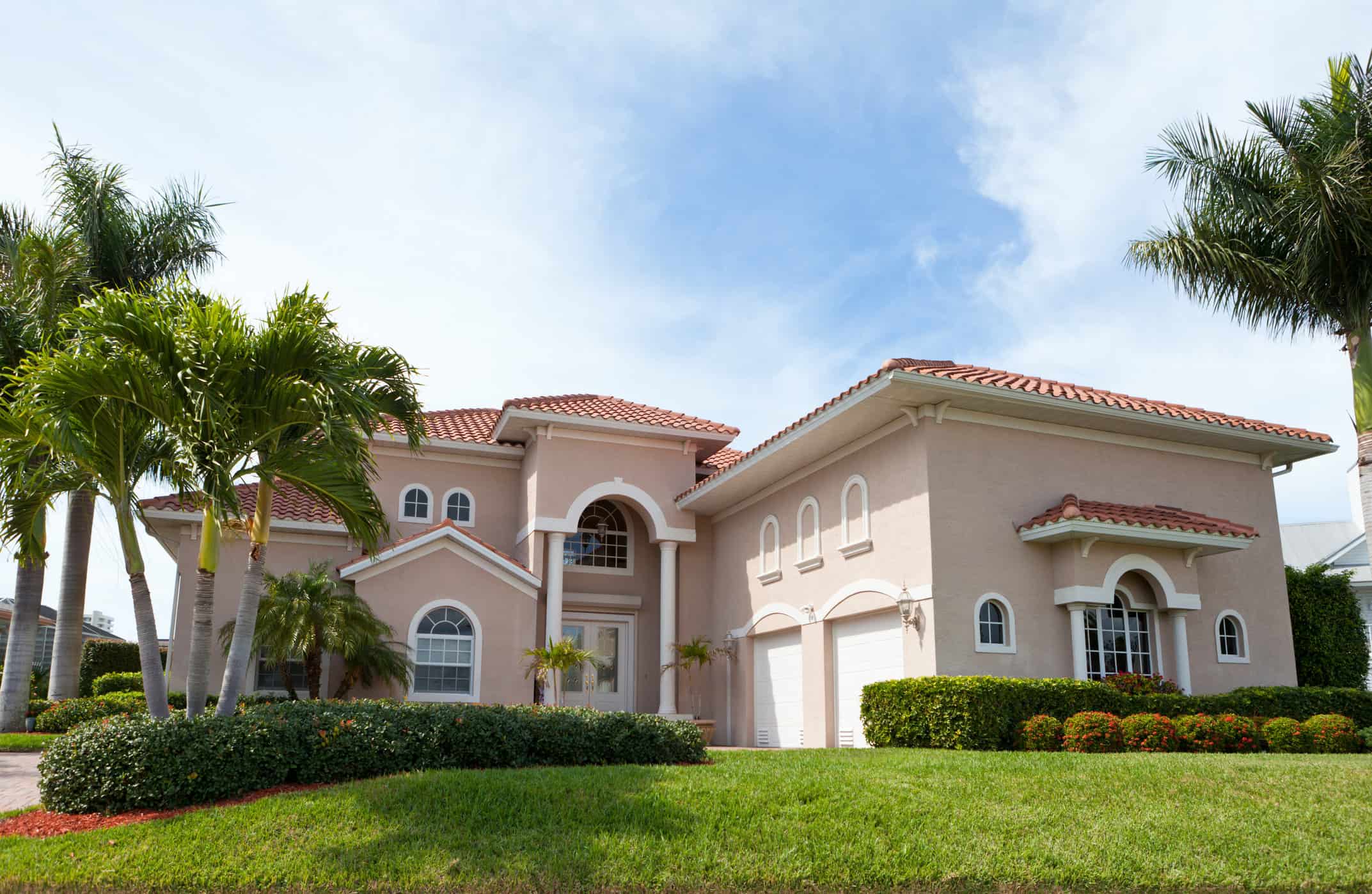 Professional Exterior House Painting Freshly painted peach stucco home with terra cotta roof and palm trees — professional exterior painting