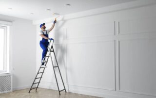 Handyman Painting Ceiling With White Dye Indoors