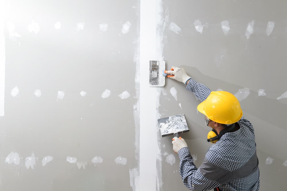 plasterer In Working Uniform Plastering The Wall