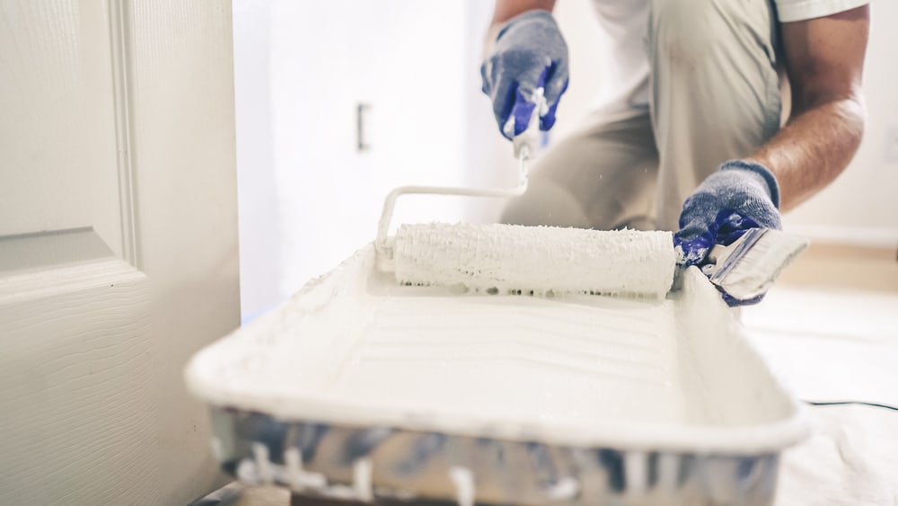 Close Up Shot Of White Paint Being Applied On A Paint Roller