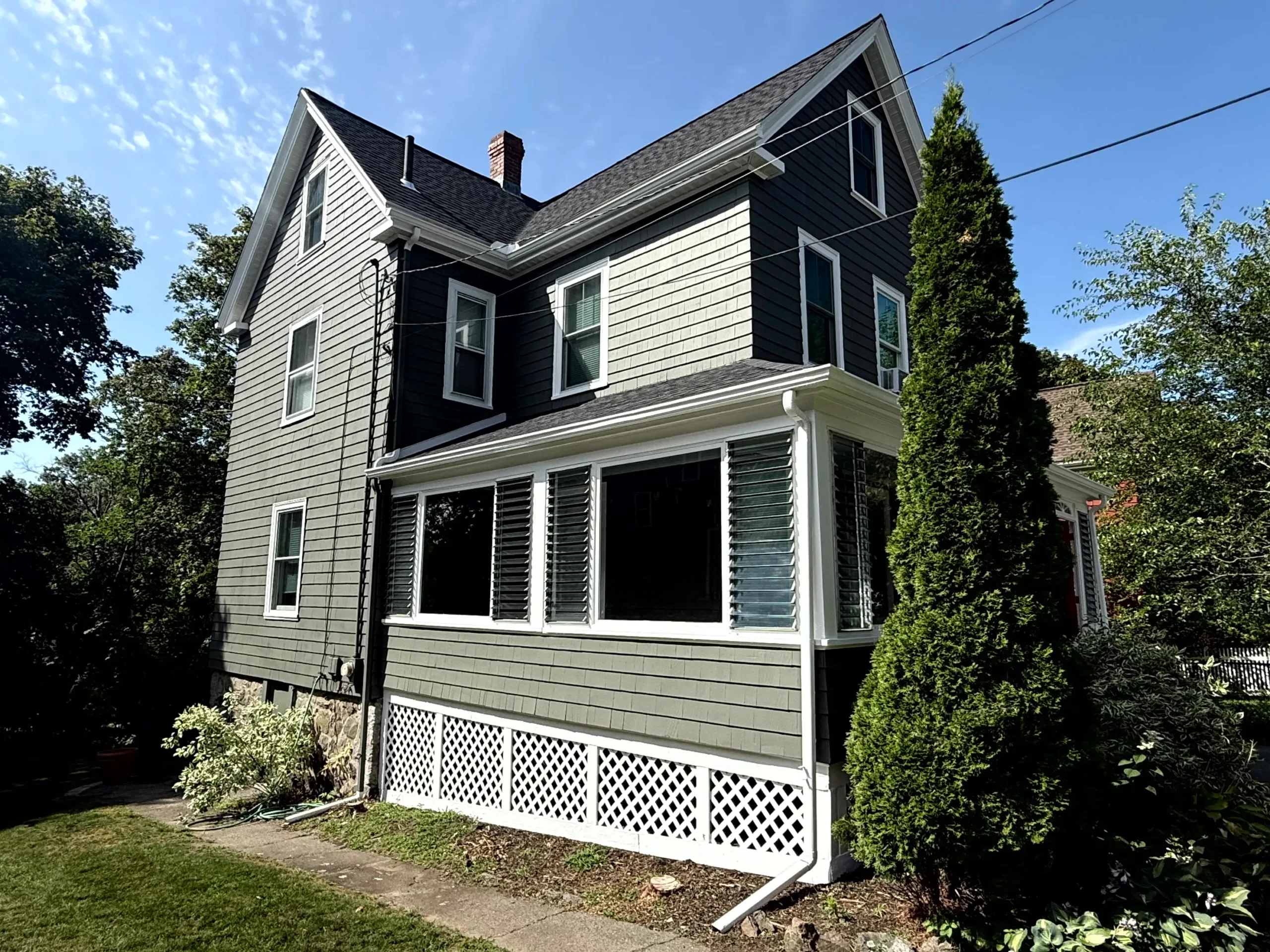 IMG_0549 Charming residential house with newly painted green siding and bright white window trim.