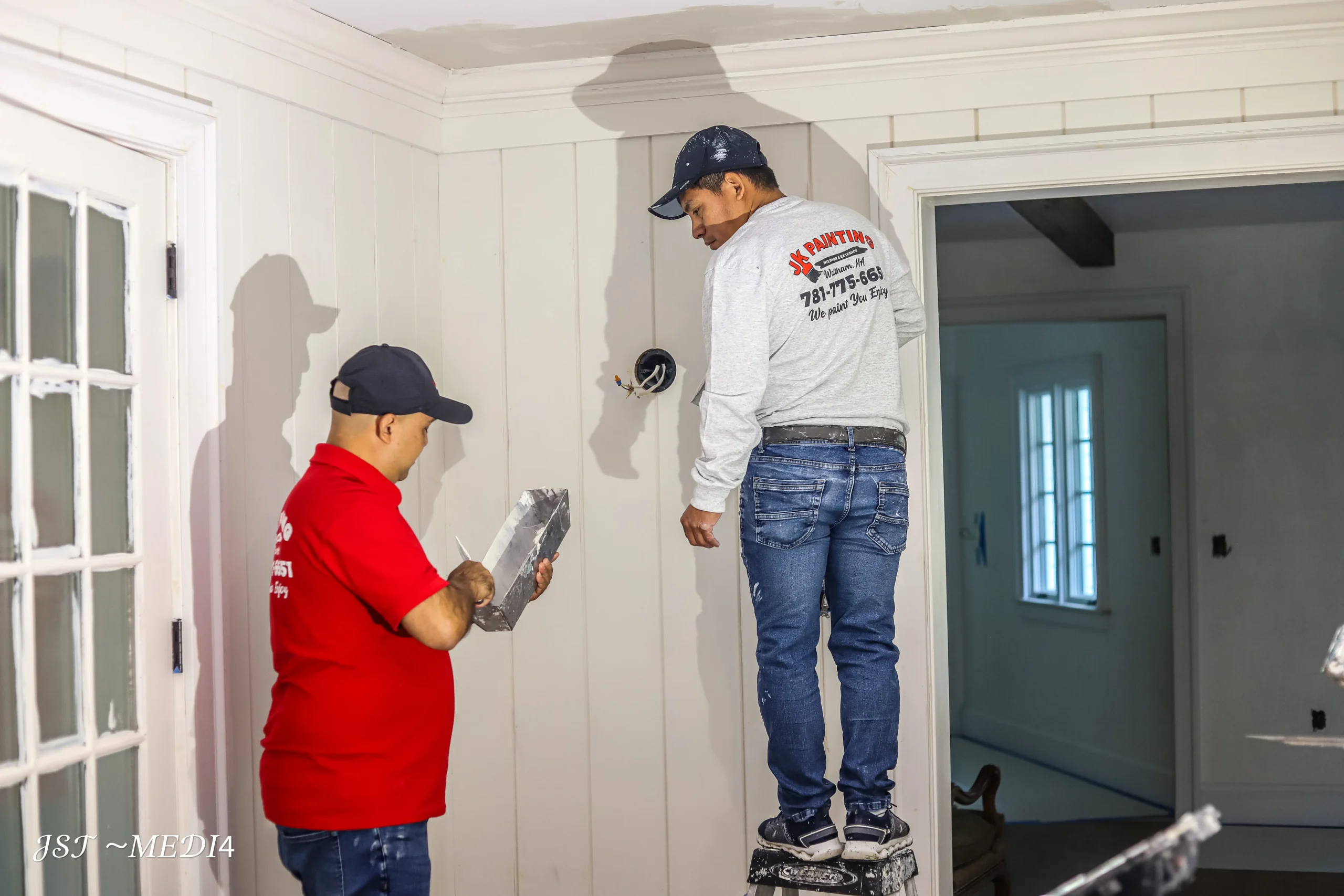 Professional Painters Preparing Interior Walls for Residential Painting Two professional painters meticulously preparing interior walls and ceilings for a fresh coat of paint.