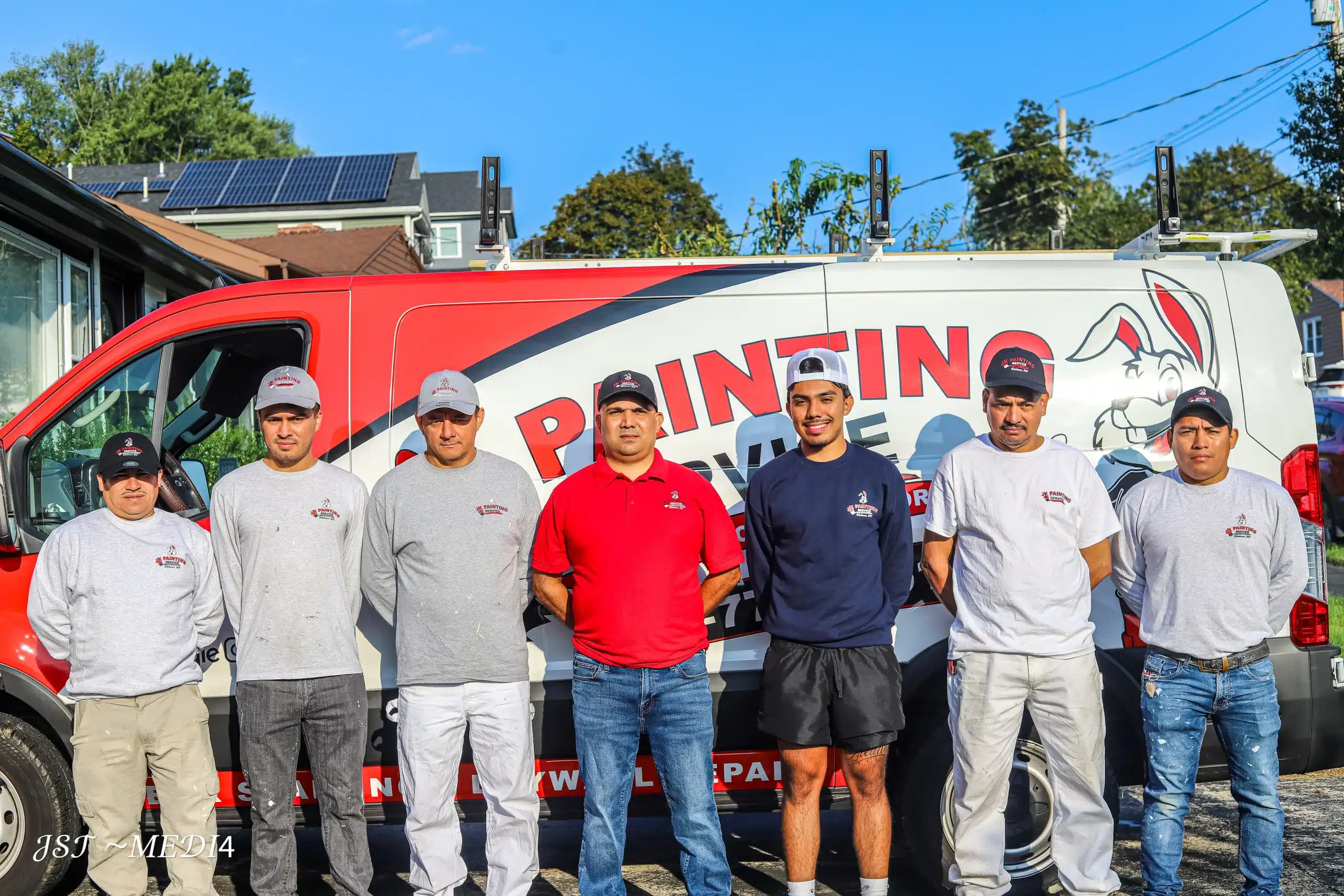 Professional Painting Team with Branded Service Van Our professional painting team stands proudly with their branded service van, ready for your next project.